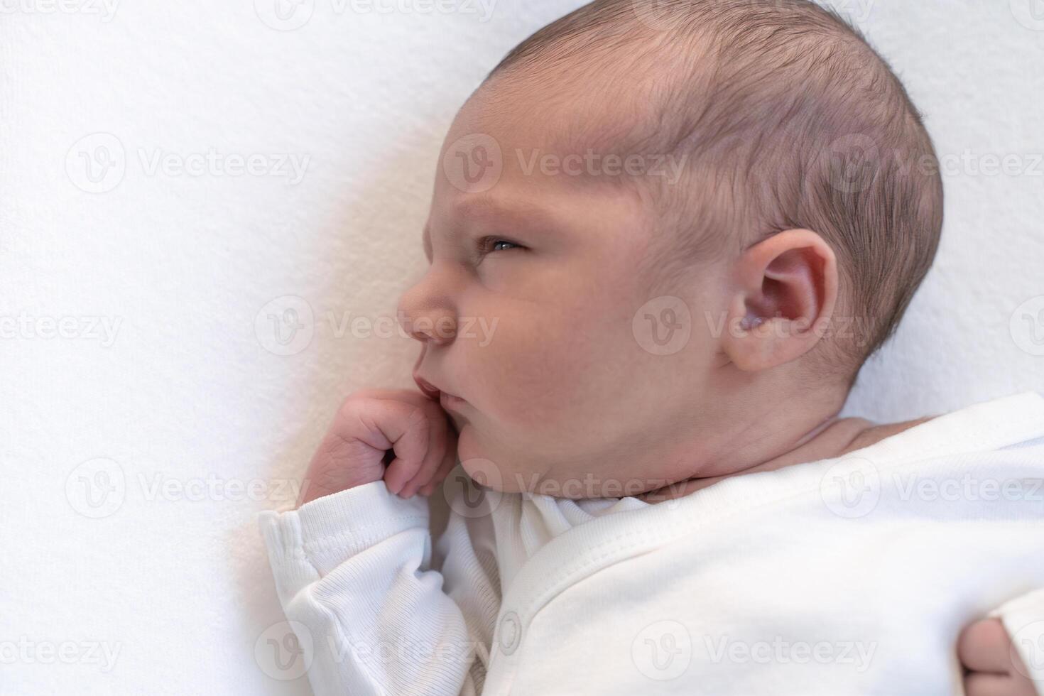 Sleeping newborn baby on white blanket banner. Beautiful portrait of little child close-up. photo