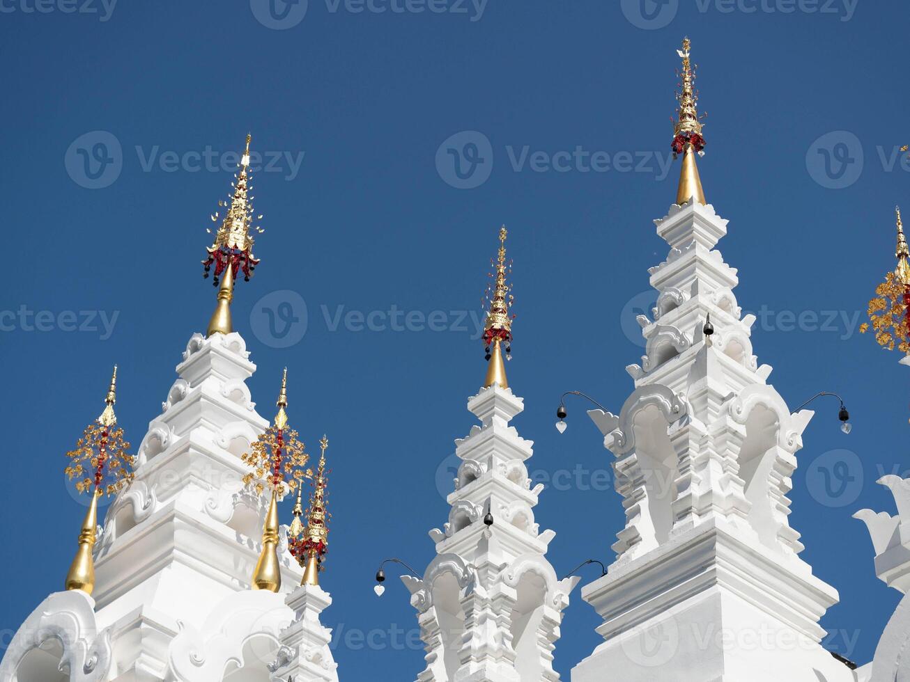 White and gold pagoda on a clear sky background in a Thai temple. photo