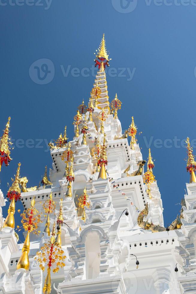 White and gold pagoda on a clear sky background in a Thai temple photo