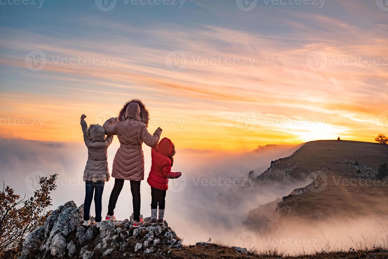 Happy family trip in the mountains during the hike, adventure travel. Concept of strong super hero mama - mother. photo