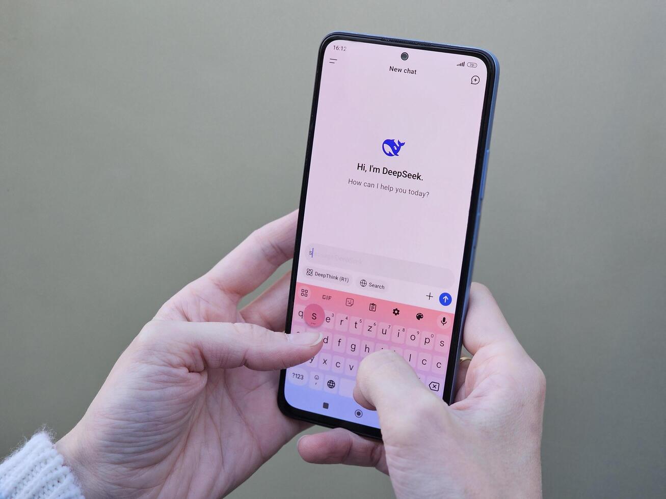 Travnik, Bosnia and Herzegovina, 02.08.2025. Close up of Asian female hands using DeepSeek app chat on phone to solve a reasoning problem on an isolated background, real photo. photo