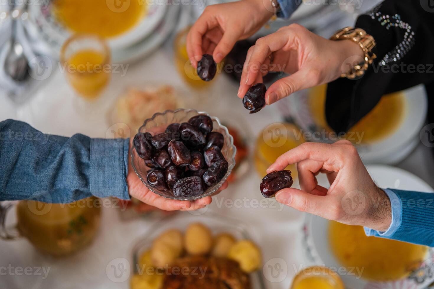 Happy Muslim family having iftar dinner to break fasting during Ramadan dining table at home group of Islamic people eating a healthy food dates together sharing and giving. photo
