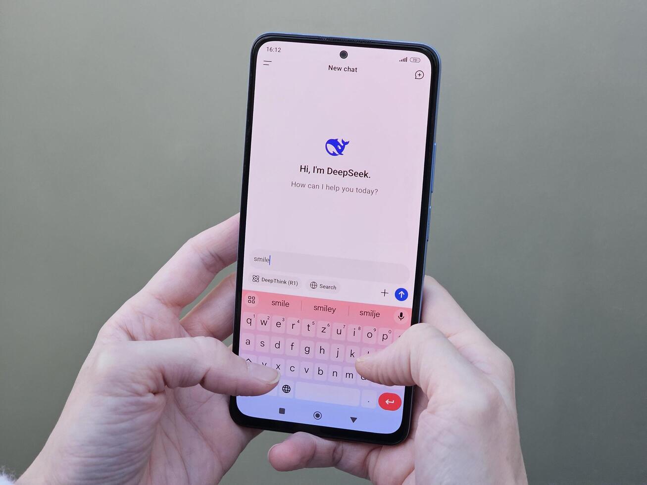 Travnik, Bosnia and Herzegovina, 02.08.2025. Close up of Asian female hands using DeepSeek app chat on phone to solve a reasoning problem on an isolated background, real photo. photo