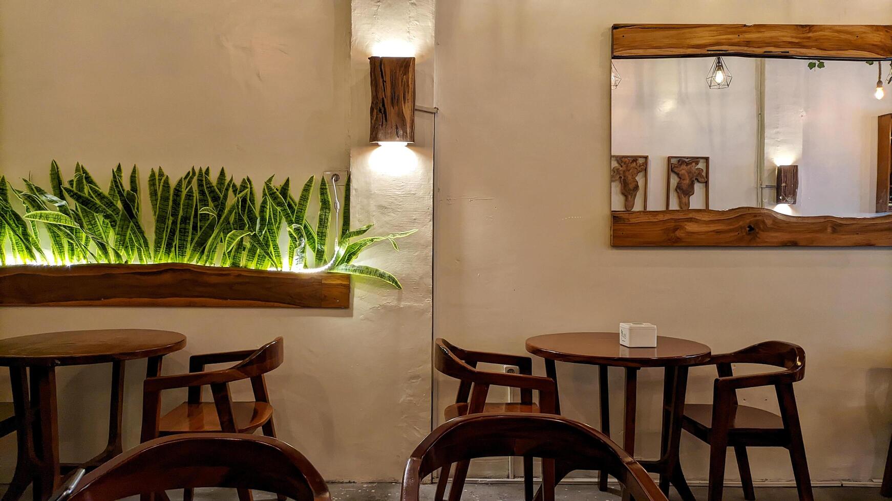 Medan, Indonesia February 5 2025 - Interior of a cafe or restaurant, wooden chairs and tables with a large mirror attached to the wall. photo