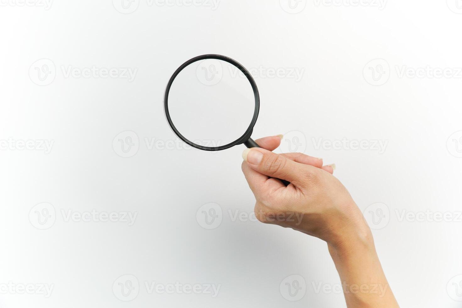 A person holding a magnifying glass over a white background photo