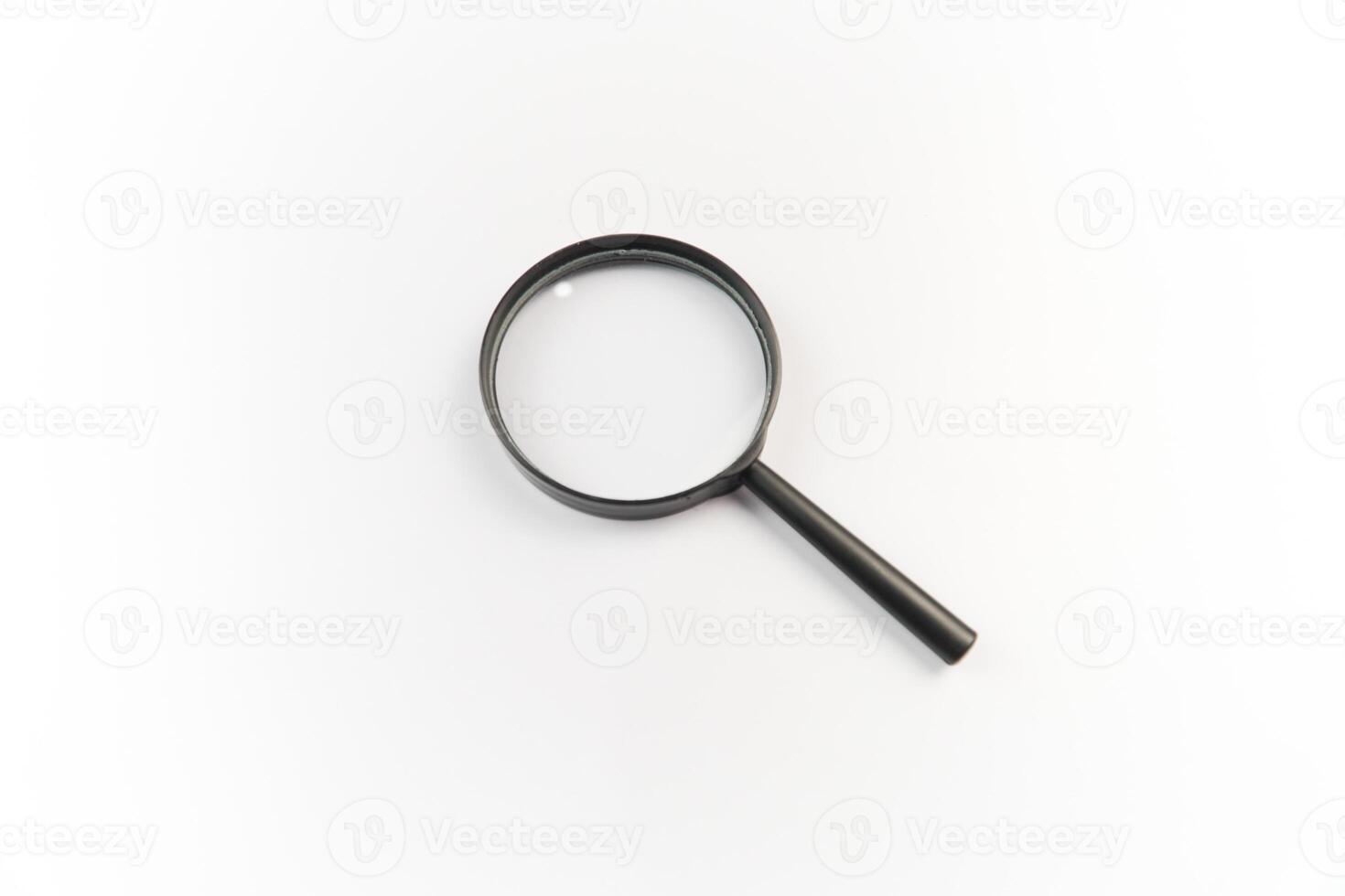 A magnifying glass is shown on a white surface photo