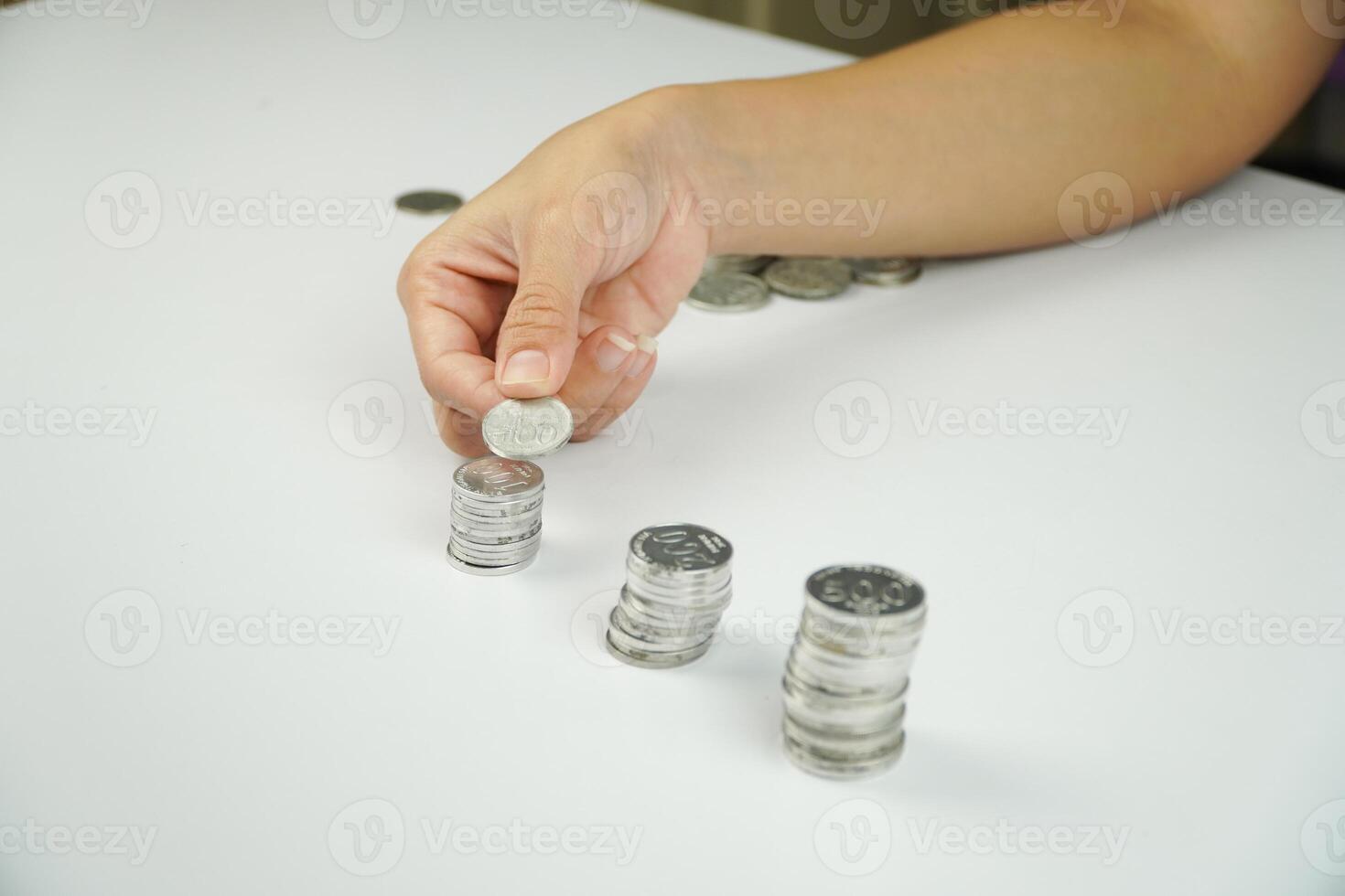 A person putting coins into a stack photo