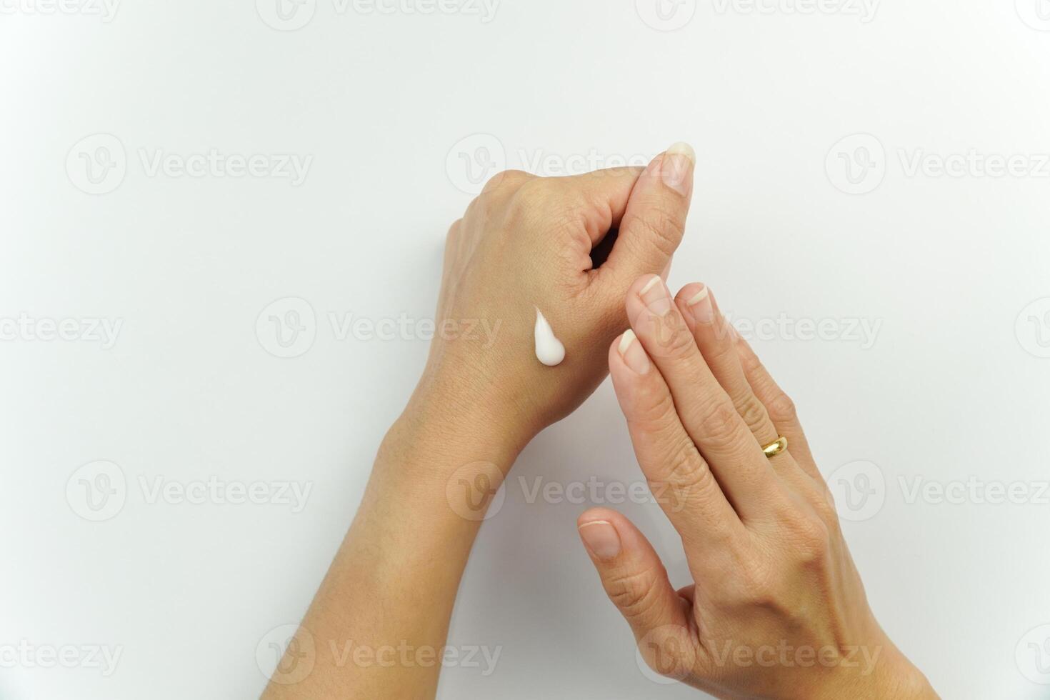 Hands of woman applying cream on white background photo