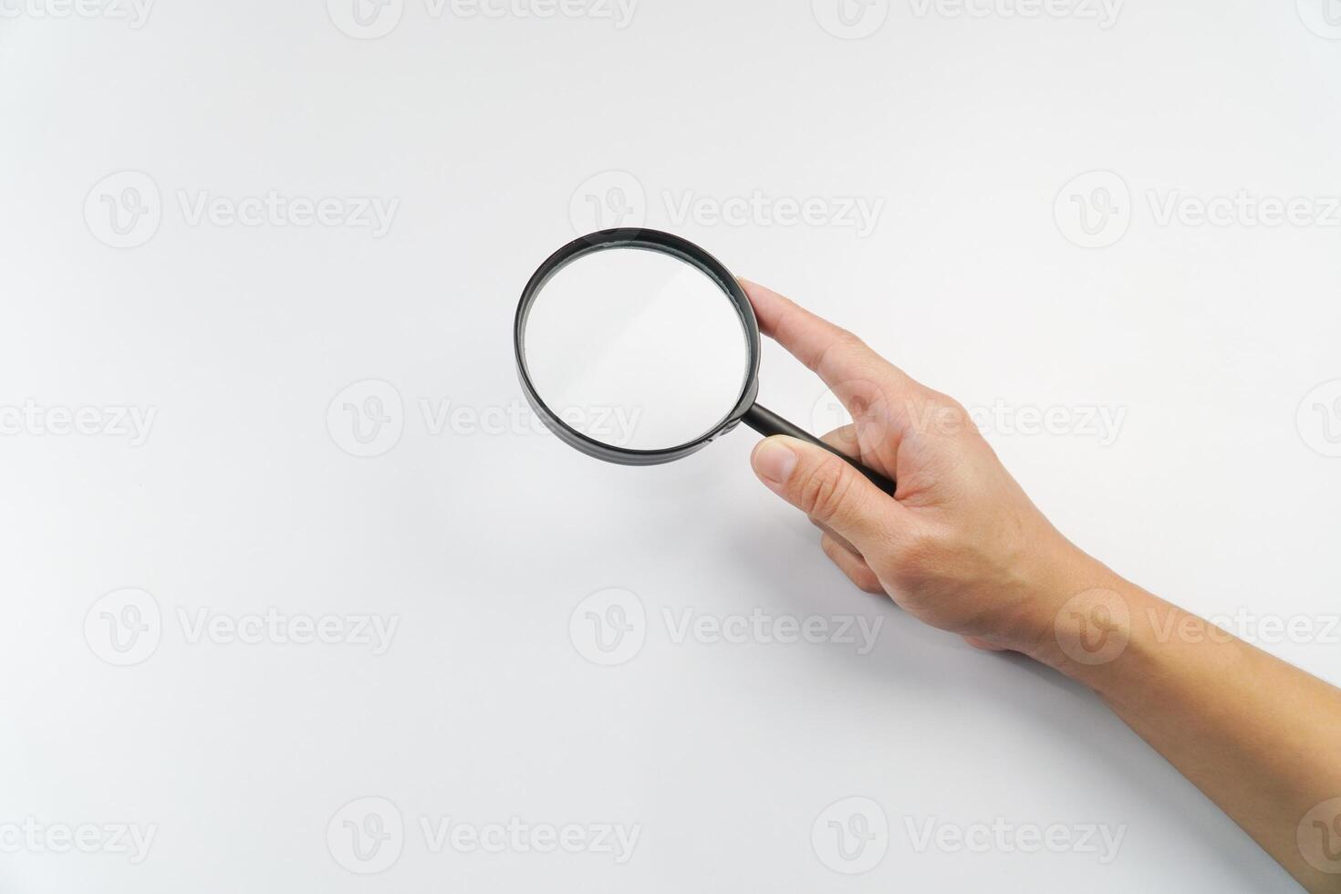 A person holding a magnifying glass over a white background photo