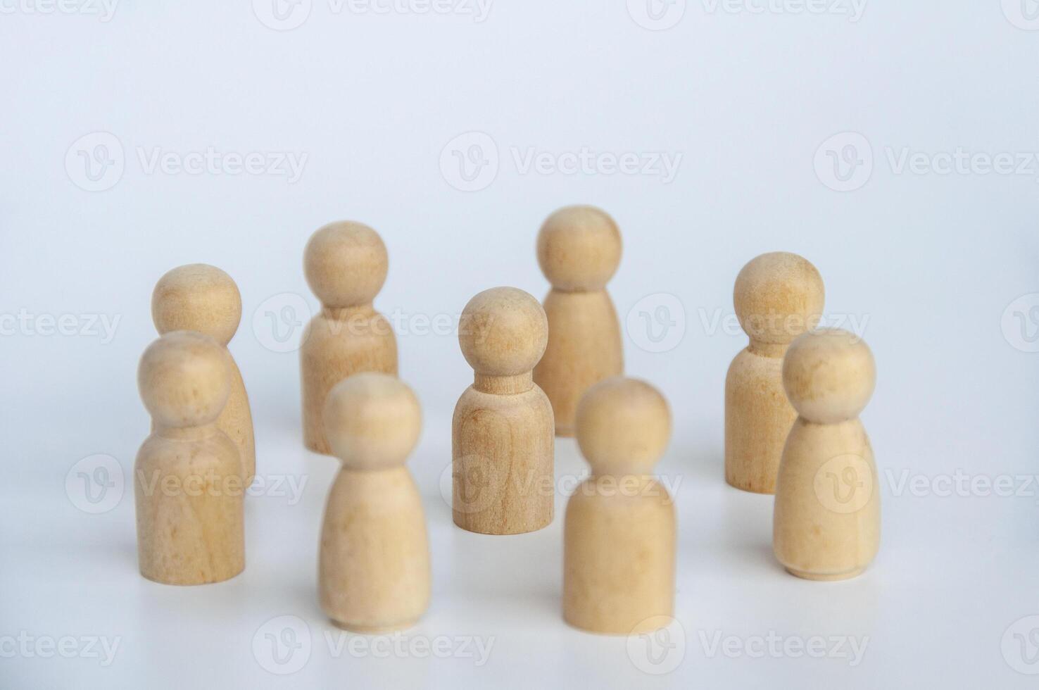 Wooden figure doll in the center of all other figure dolls. Leadership concept photo