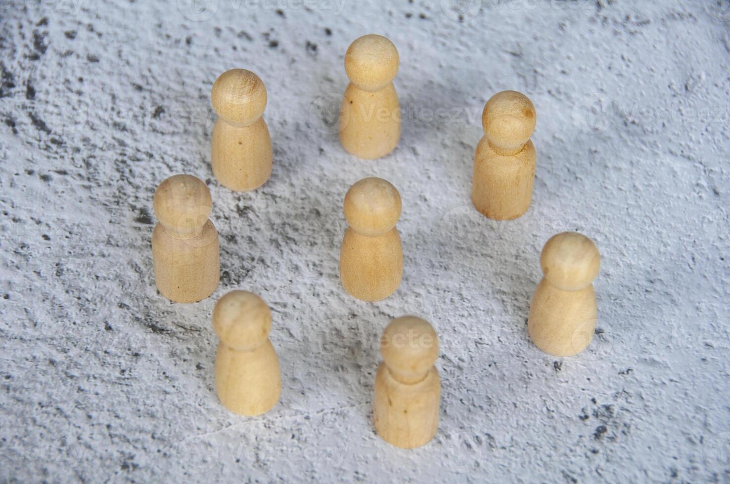 Wooden figure doll representing a leader. Surrounded by followers. Leadership concept photo