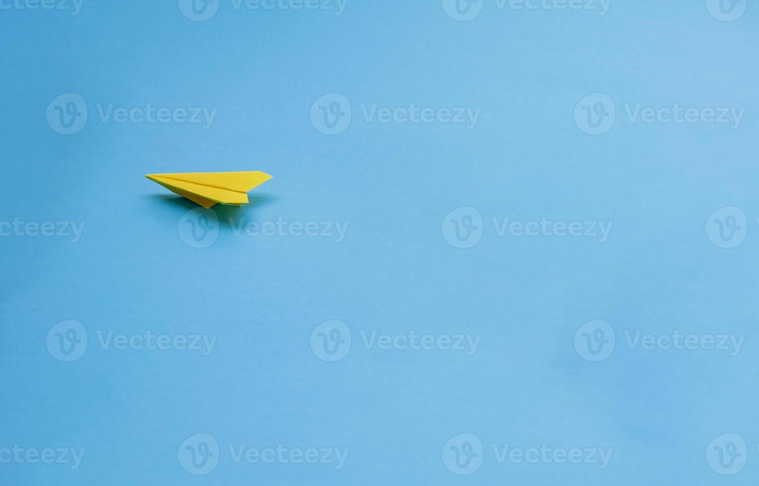 Yellow paper airplane on blue background photo