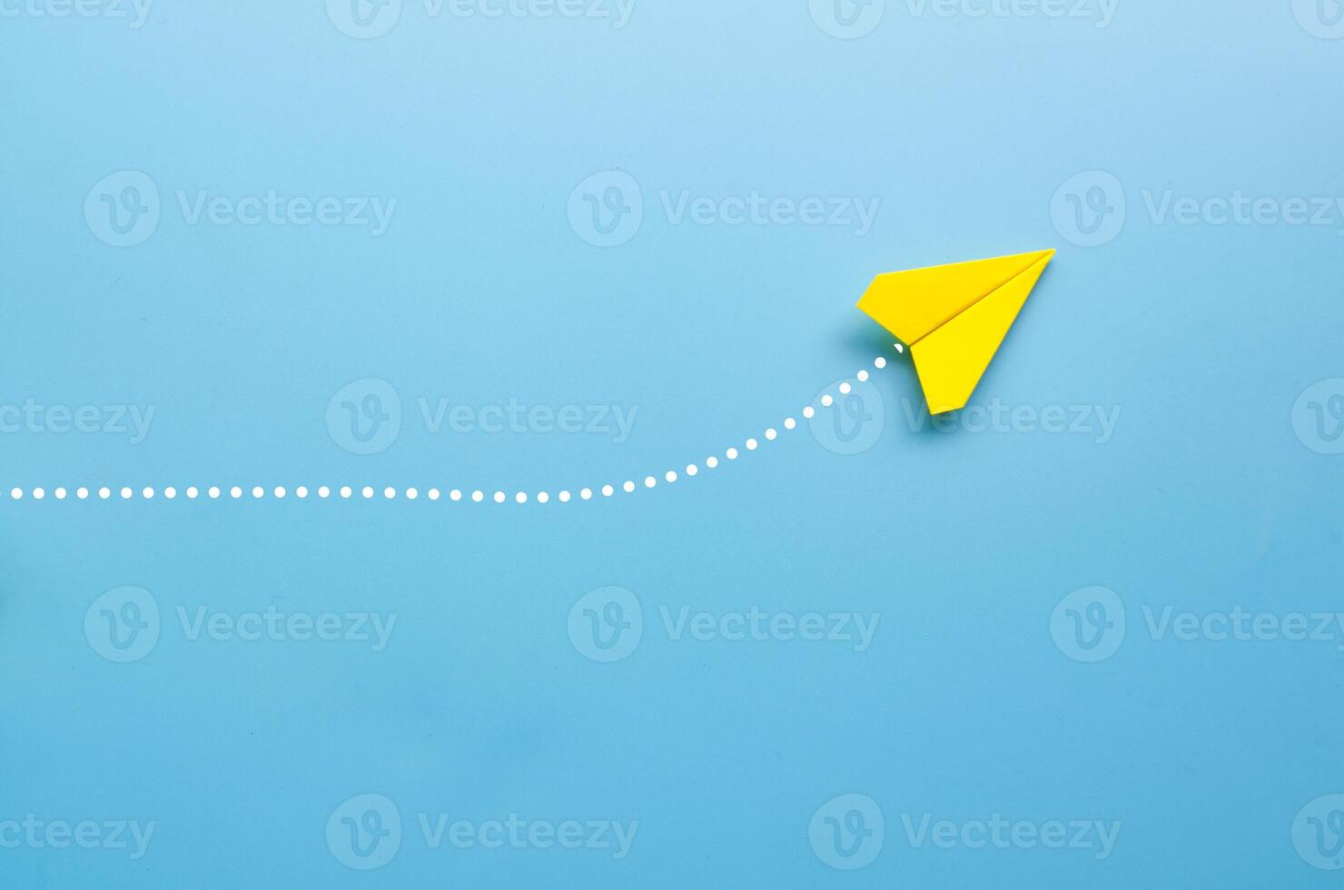 Top view of origami yellow paper airplane on blue background photo