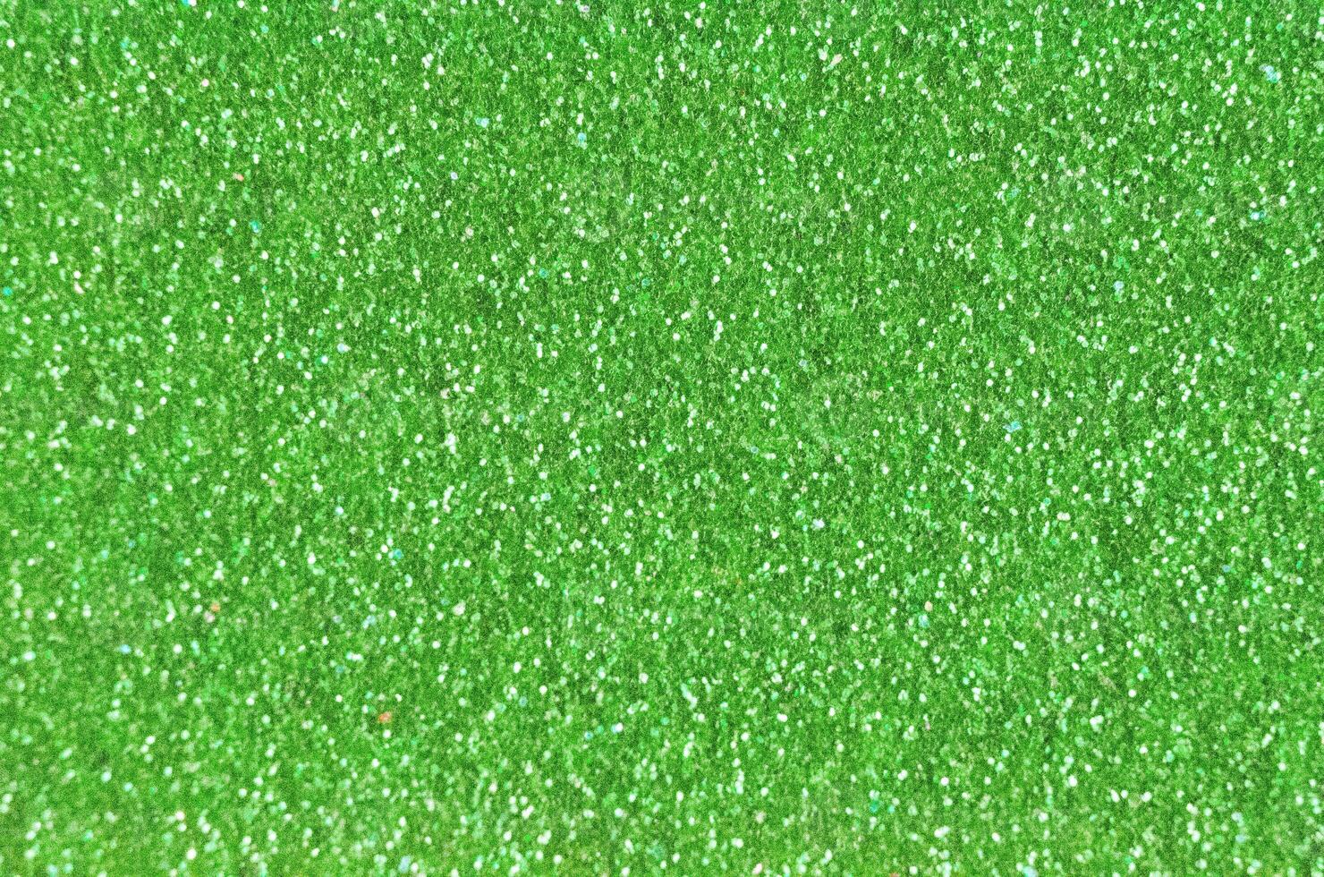 Close up of a green glitter or sparkle texture and can be used as a background or wallpaper for designs. photo