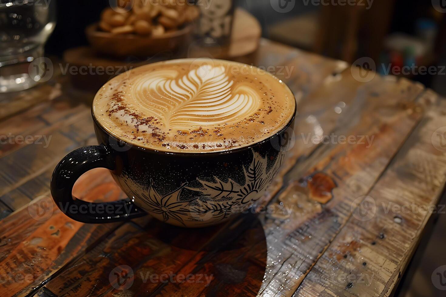 A latte with a leaf design on top of a wooden table photo