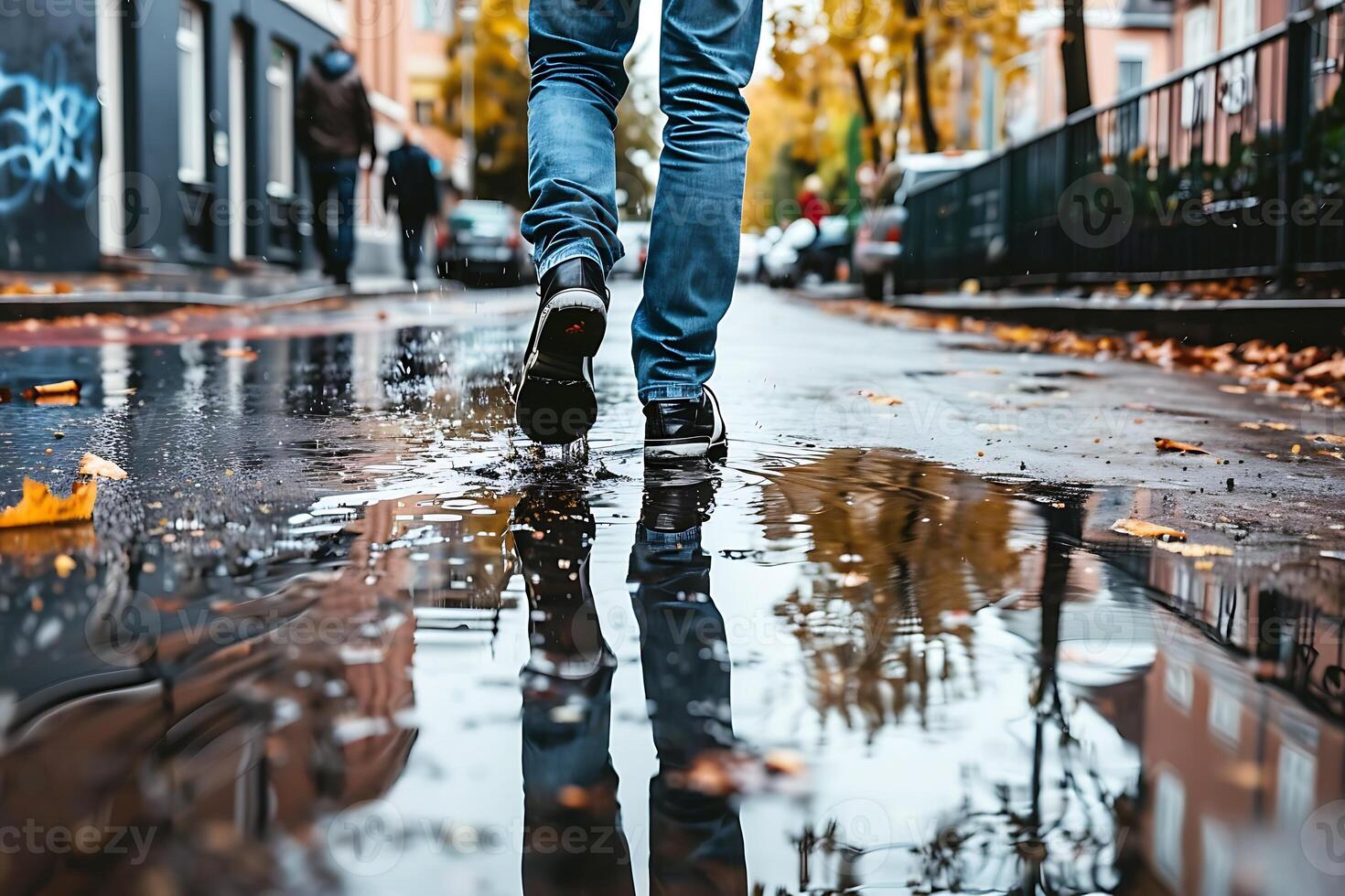 A person walking on a wet street with their shoes in the puddle photo