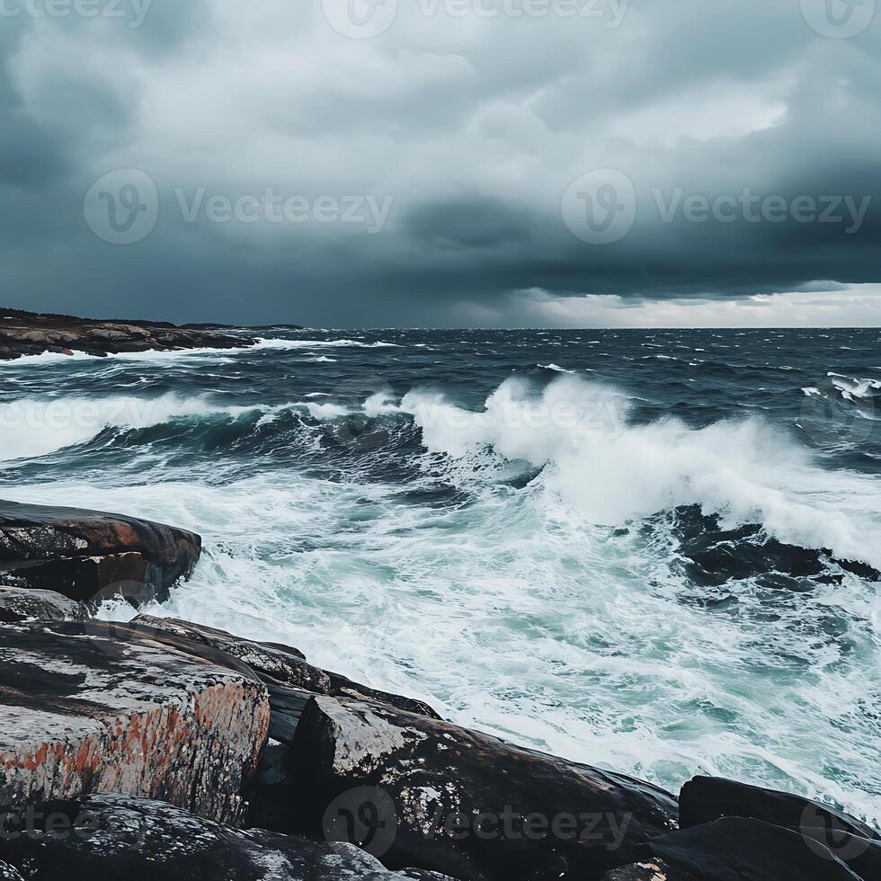 A person standing on a rocky shoreline with a large wave crashing in the background photo