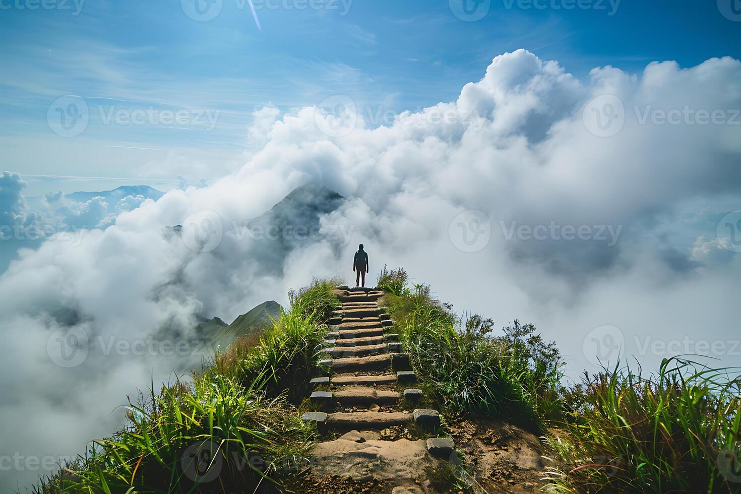 A person standing on a path leading up to the clouds photo