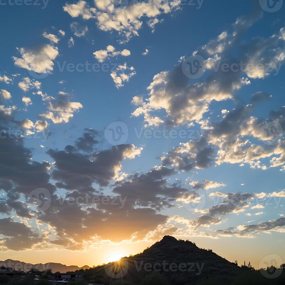 A sunset over the mountains with clouds in the sky photo