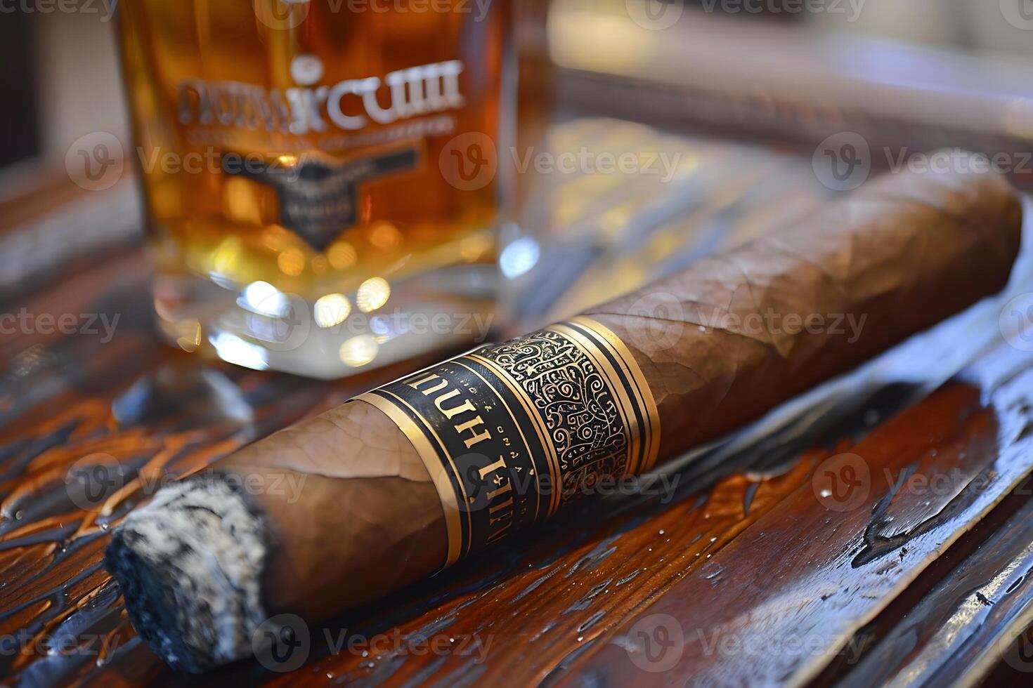 A cigar sitting on a table next to a glass of whiskey photo