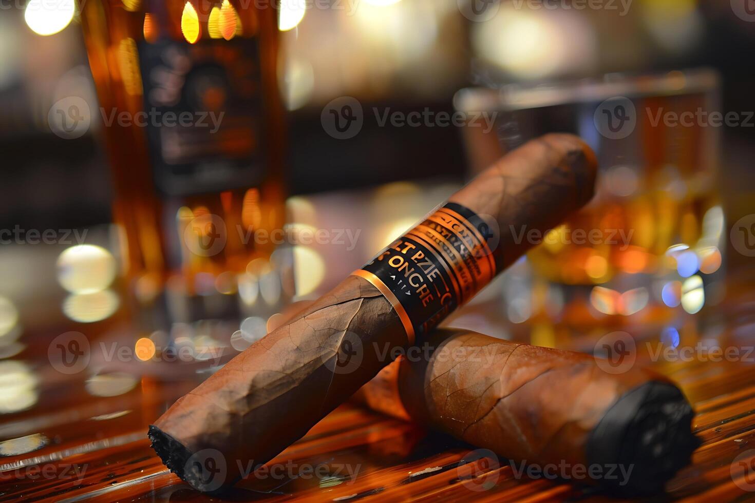 A cigar sitting on a table next to a glass of whiskey photo