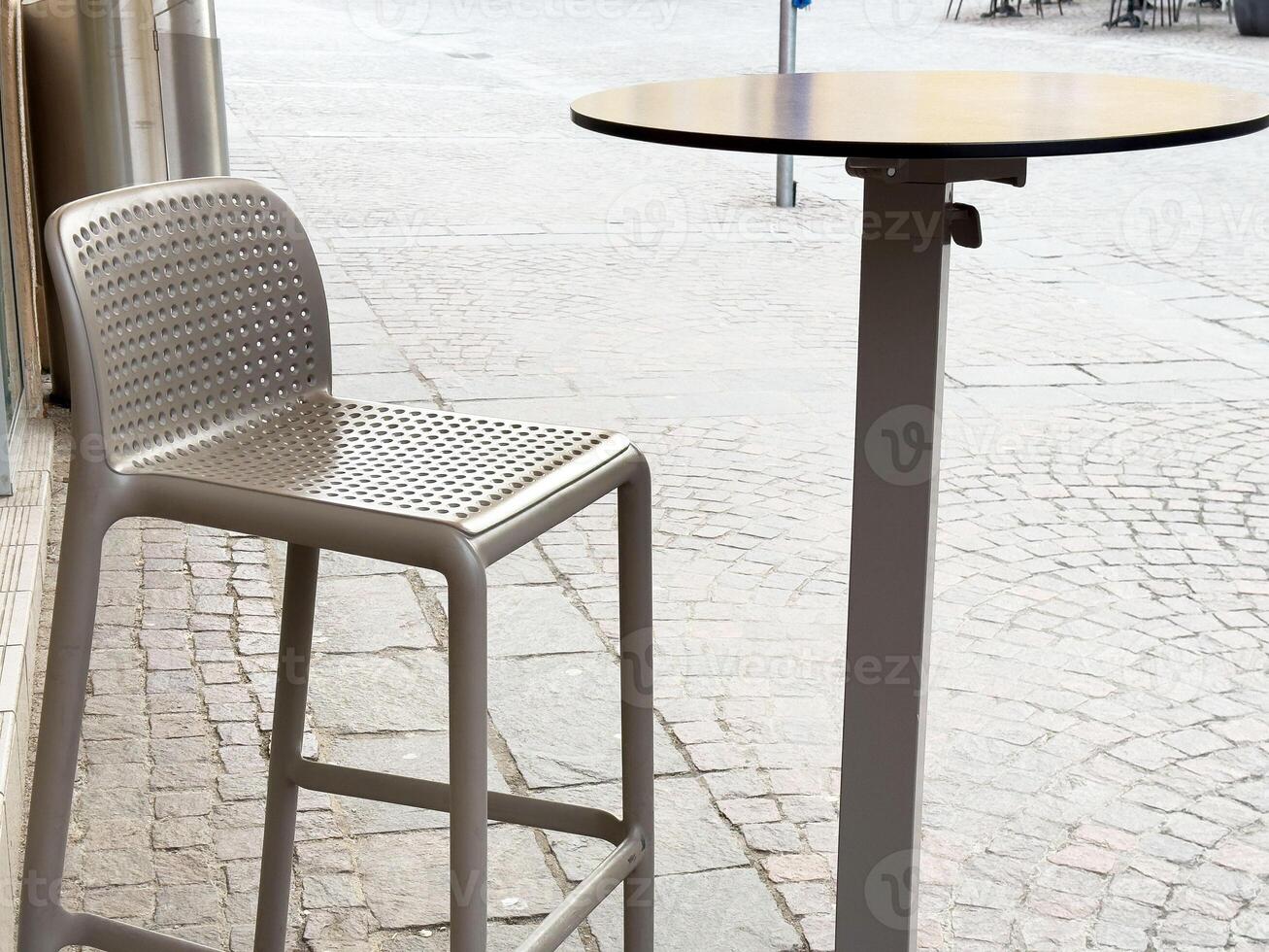 Outdoor cafe setting with modern bar stool and round table photo