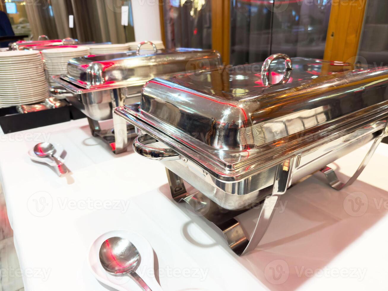 Catering buffet setup with stainless steel chafing dishes and cutlery photo