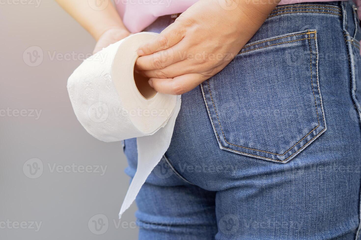 Close up hands of woman take toilet paper. Back view. Concept of diarrhea. photo
