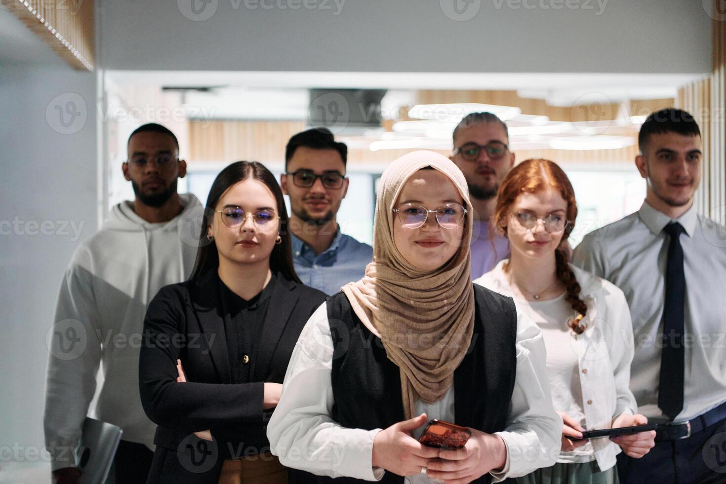 A group of business professionals standing together, taking a well-deserved break from their busy workday, showcasing camaraderie, teamwork, and a moment of relaxation in their dynamic workplace photo