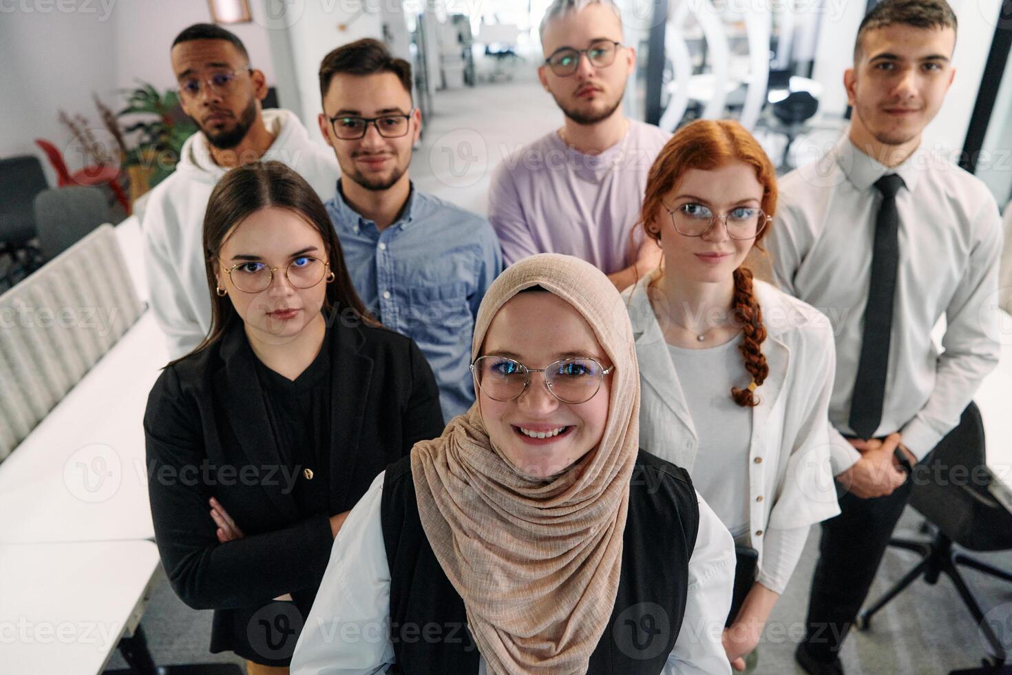 A group of business professionals standing together, taking a well-deserved break from their busy workday, showcasing camaraderie, teamwork, and a moment of relaxation in their dynamic workplace photo