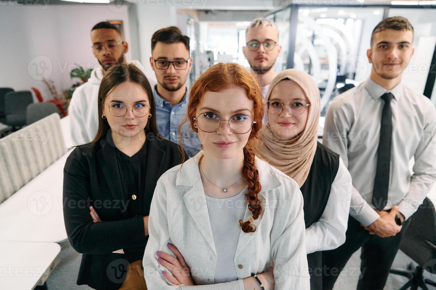 A group of business professionals standing together, taking a well-deserved break from their busy workday, showcasing camaraderie, teamwork, and a moment of relaxation in their dynamic workplace photo