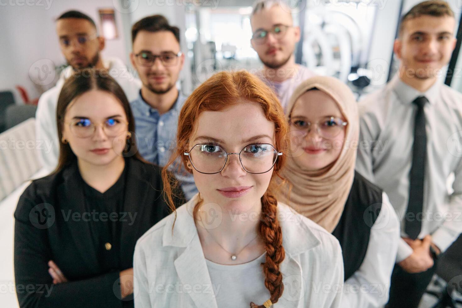 A group of business professionals standing together, taking a well-deserved break from their busy workday, showcasing camaraderie, teamwork, and a moment of relaxation in their dynamic workplace photo