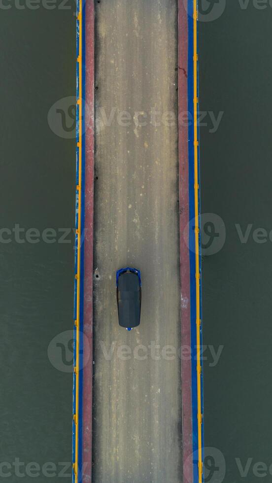 Aerial view of cars driving on a bridge with a river in the background photo