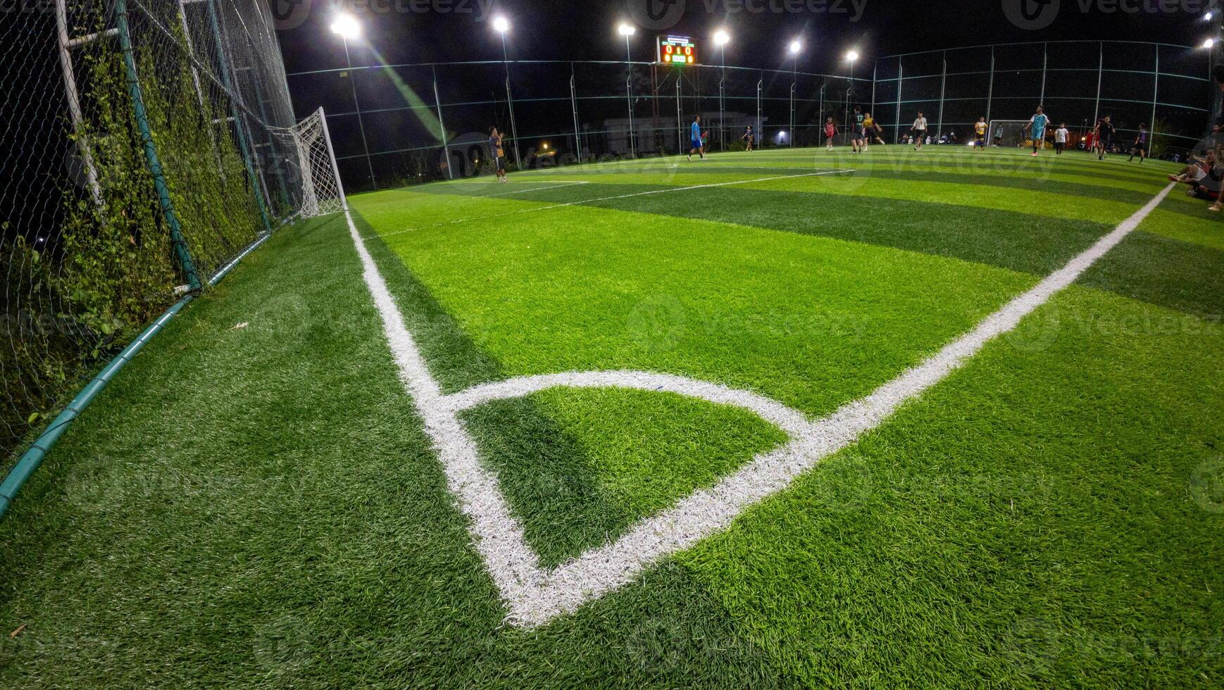 Soccer field with green grass and soccer goal in night time. photo
