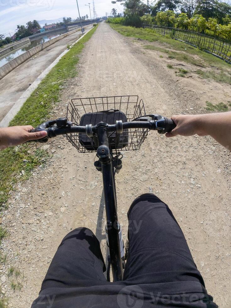 Cyclist riding bicycle on the road. View from above. POV photo