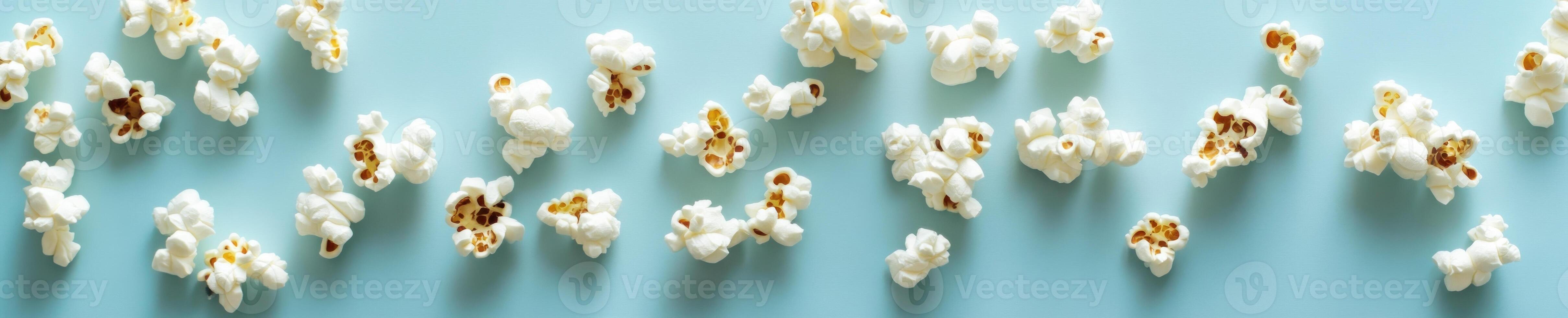 Minimalist popcorn flat lay with scattered pieces on blue background for design or decor photo