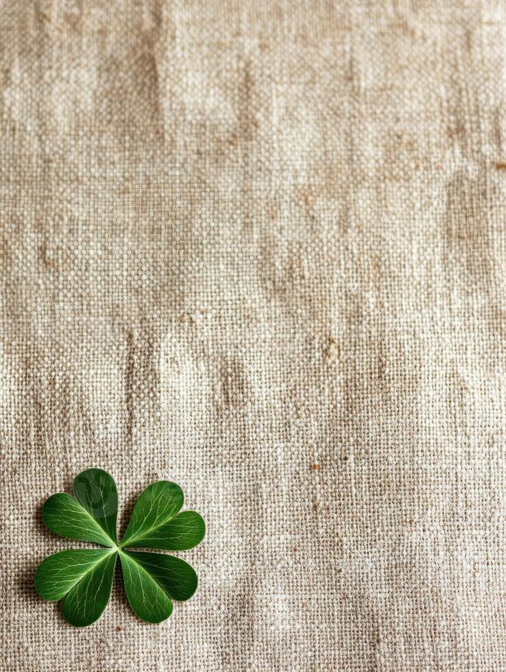 Close up of natural linen fabric with green clover leaf for eco friendly design photo