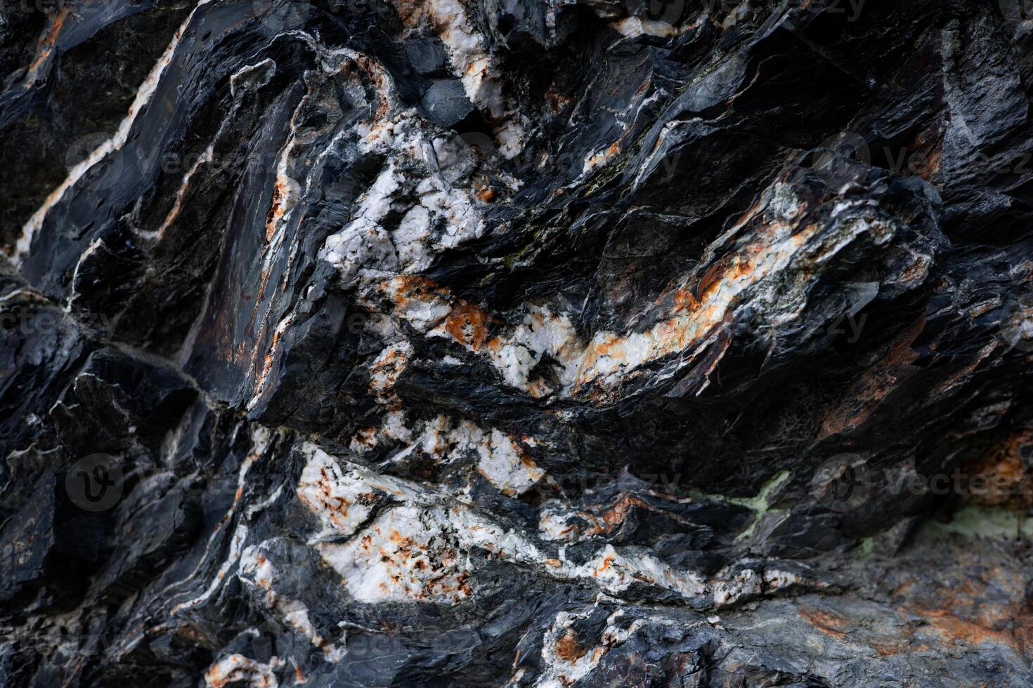 Close up of rugged rock surface with dark and light striations photo