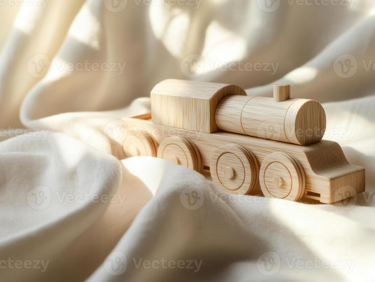 Wooden train toy resting on soft fabric surface. Childhood playtime and creativity photo