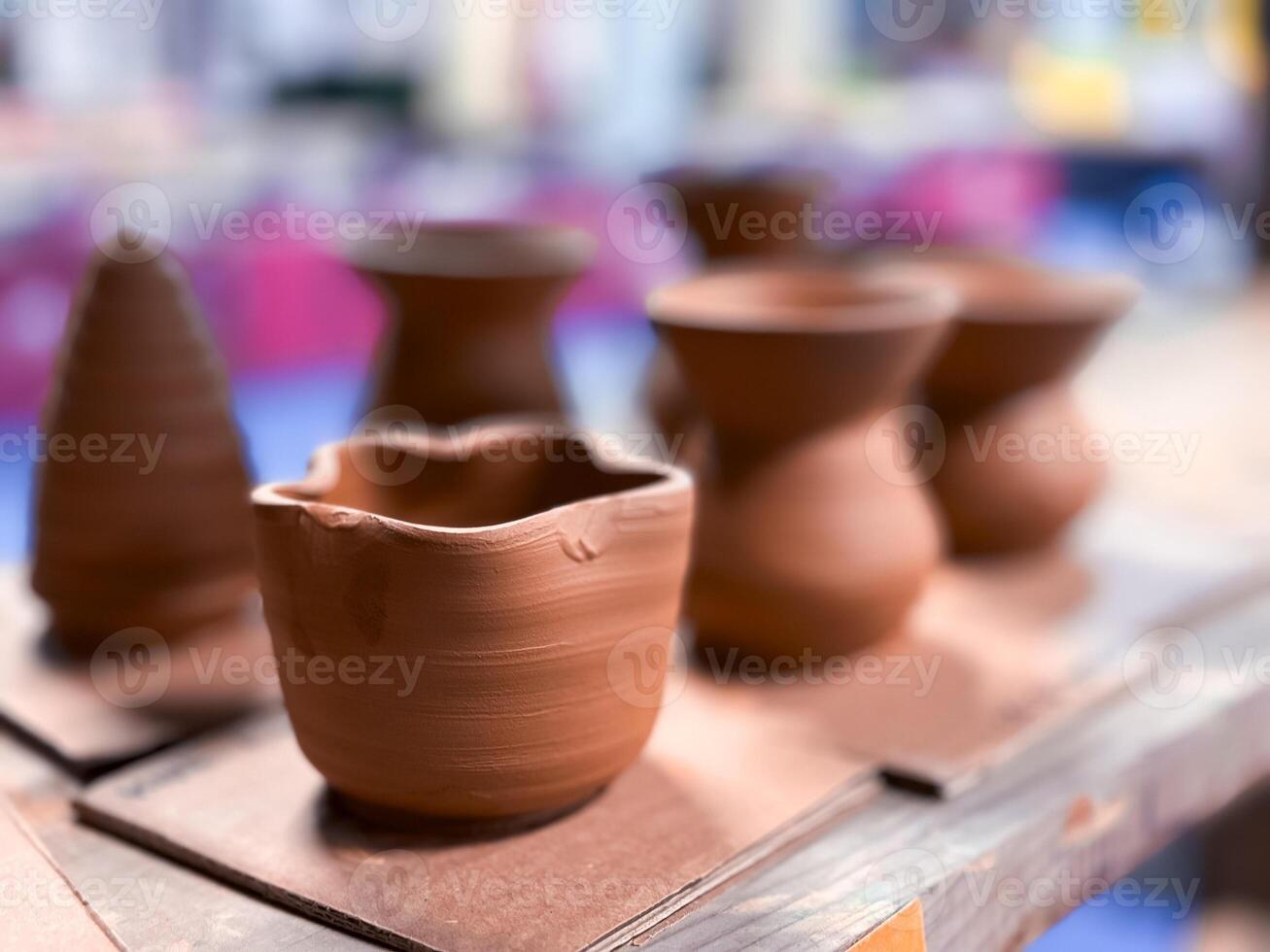 Handmade clay vessels on display in pottery workshop photo