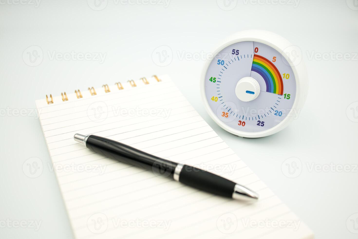 Colorful kids timer with notepad and pen on white background photo