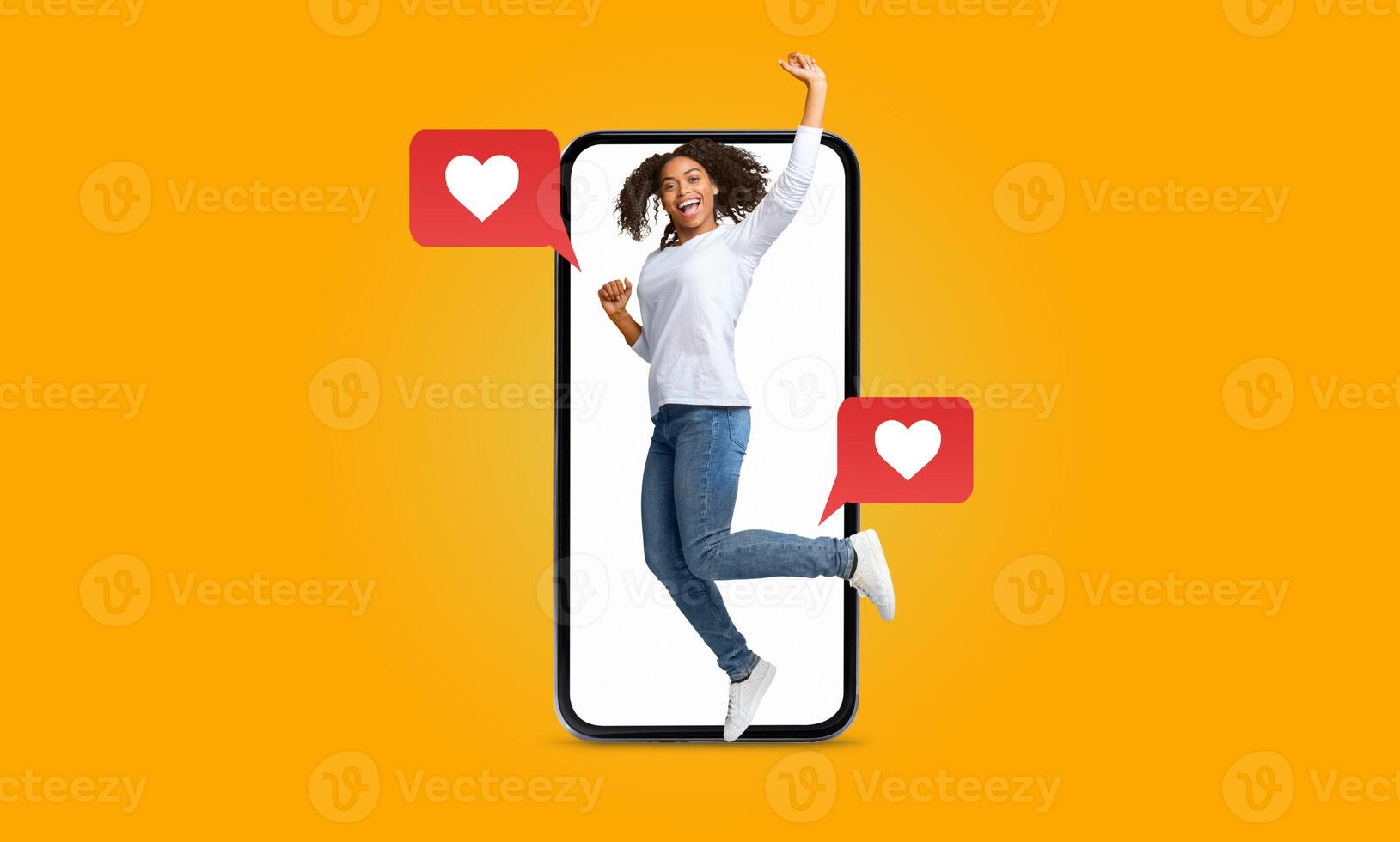A person joyfully jumps in front of a large smartphone, surrounded by heart-shaped message icons. This vibrant expression captures the excitement of connecting through social media. photo