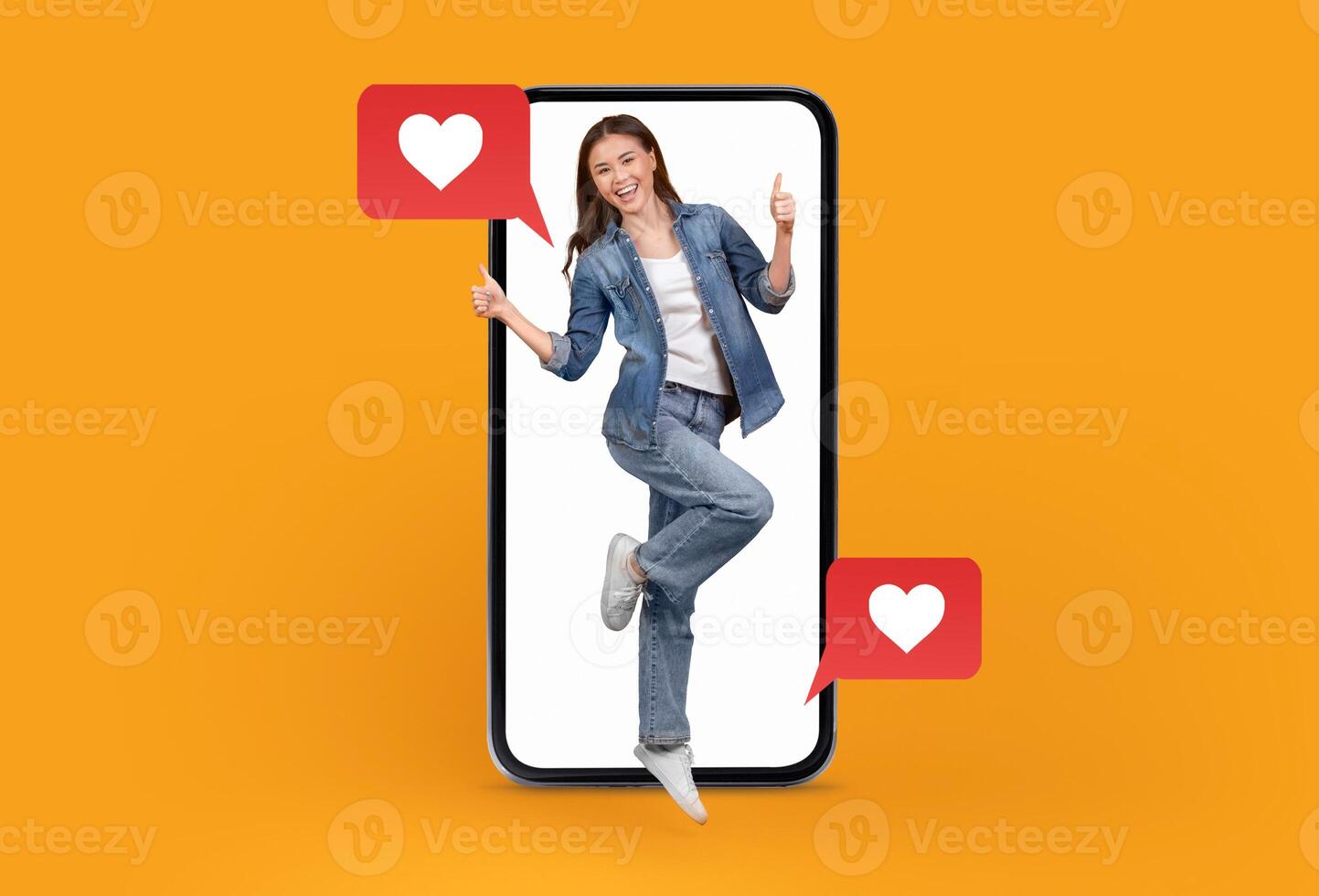 A young woman stands playfully in a smartphone screen, showing thumbs up and smiling. Heart icons float beside her, symbolizing connection and love through social media in a vibrant setting. photo
