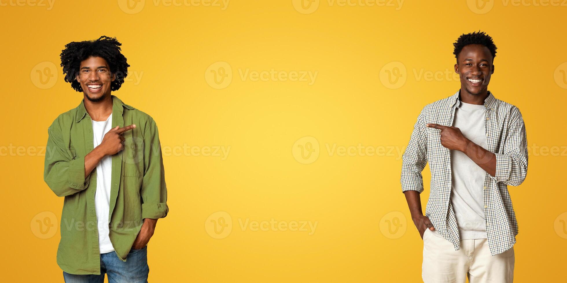 Check This. Two Cheerful African American Guys Pointing In The Middle On Beige Studio Background, Happy Black Male Friends Demonstrating Free Copy Space For Design Or Advertisement, Panorama photo