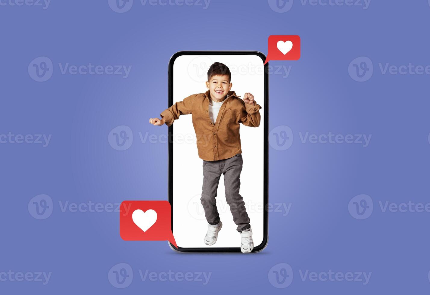 A young child joyfully dances inside a smartphone screen surrounded by heart icons. The vibrant setting showcases enthusiasm and connection through technology, perfect for Valentines Day. photo