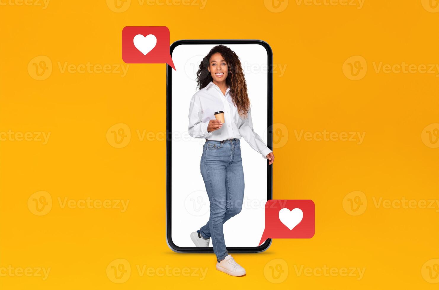 A person stands confidently inside a large smartphone, holding a drink and smiling. Heart icons float nearby, symbolizing messages and connection on a social media application during Valentine's Day. photo