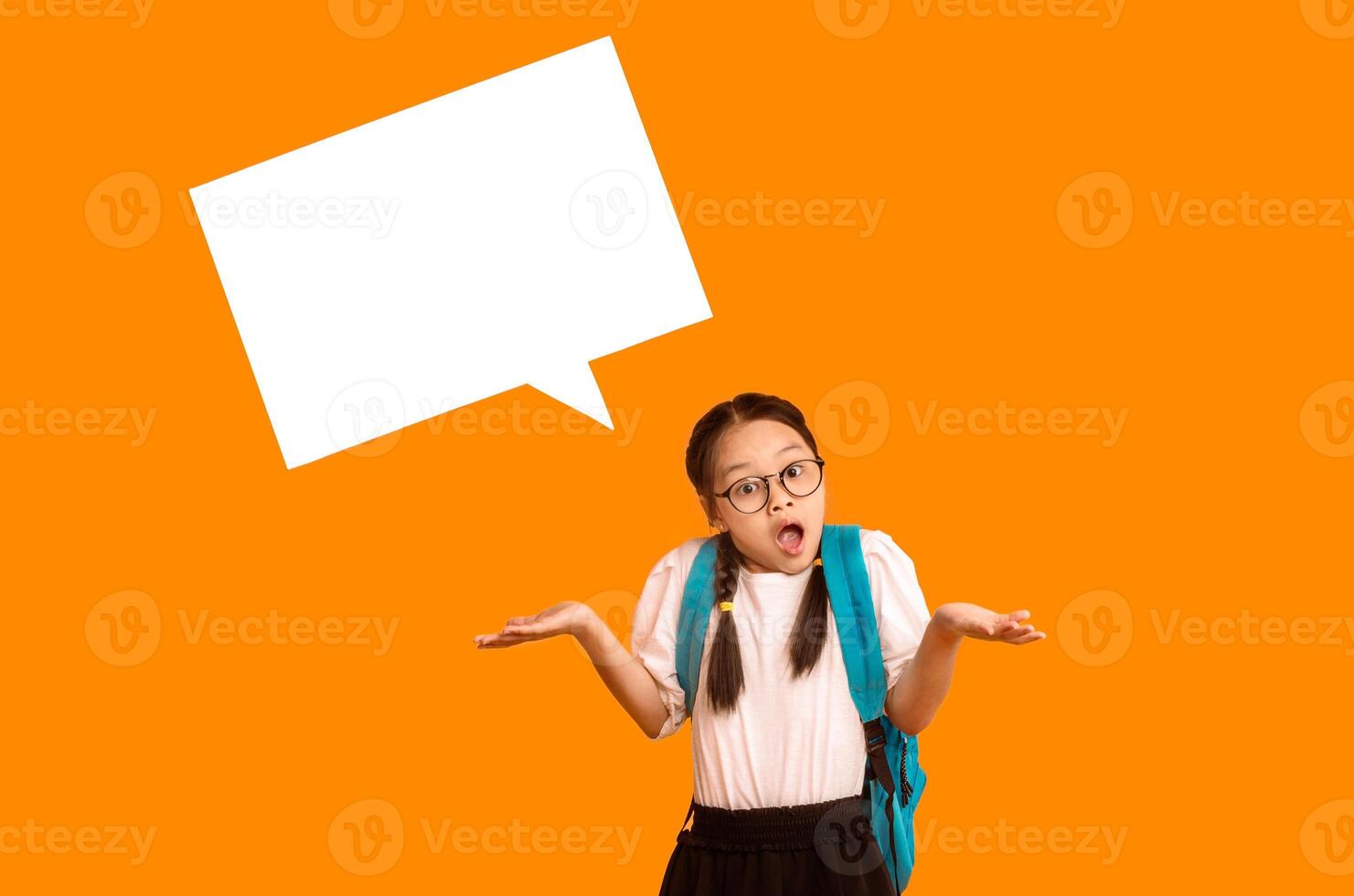 Confused Japanese Schoolgirl Looking At Camera In Shock Posing With Empty Speech Bubble Above Head On Yellow Studio Background photo