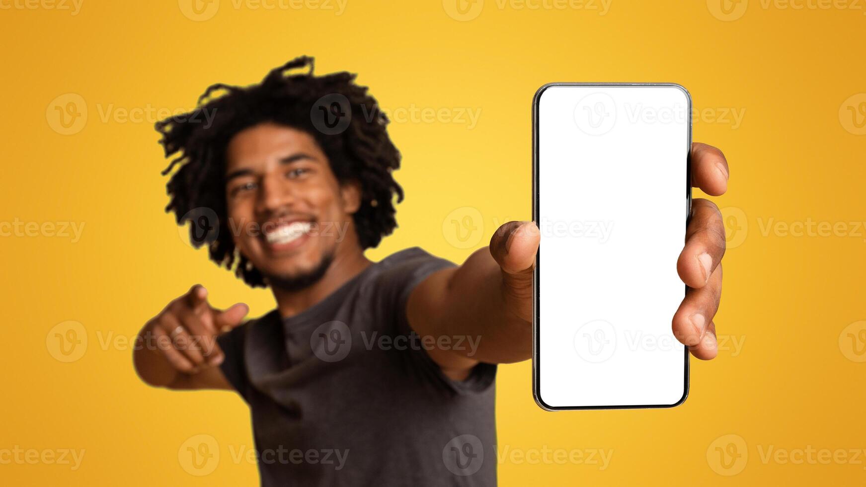 Joyful Black Guy Demonstrating Smartphone With Blank White Screen In His Hand, Cheerful Young African American Man Showing Free Copy Space For Your Ad Or Design, Standing On Beige Background, Mockup photo