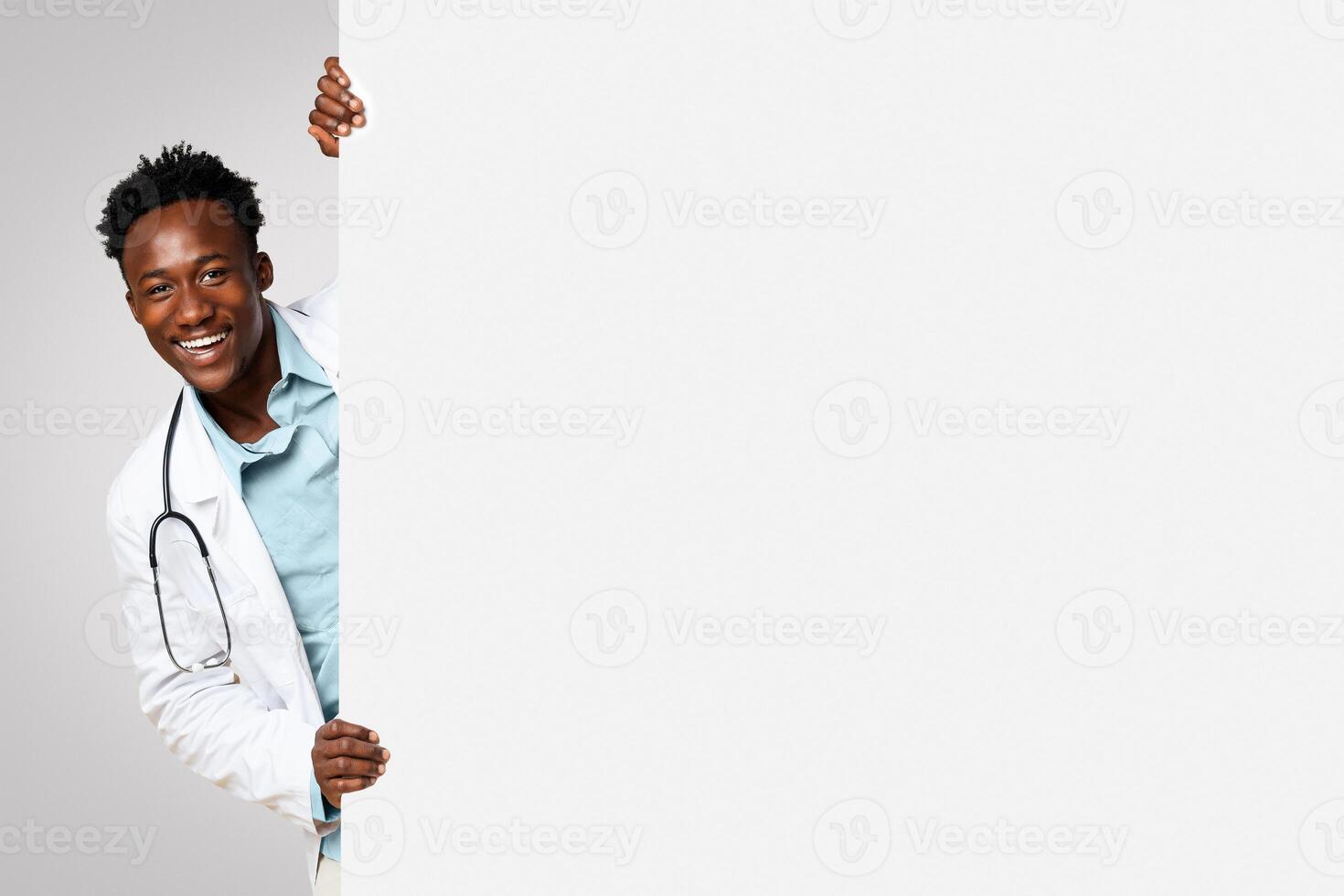 Medical Ad. Positive Black Male Doctor Peeking Out Of Big Blank Advertisement Board, Handsome African American Therapist In Uniform Demonstrating Empty Copy Space On White Placard, Panorama photo