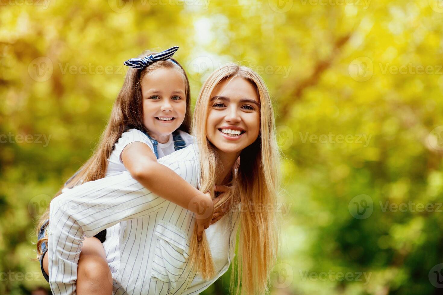 Happy Mother Carrying Daughter Piggyback Enjoying Time Together And Having Fun Outdoors Walking In Park. Free Space photo